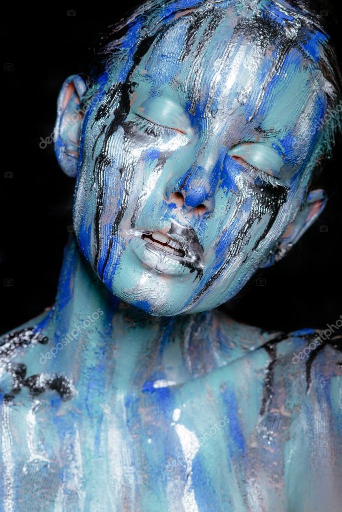 Abstract art makeup. Face, neck and hair girls smeared with bright colors  of blue, blue and silver colors. The paint flows. On the face of silver  tears. Holi festival Stock Photo by ©